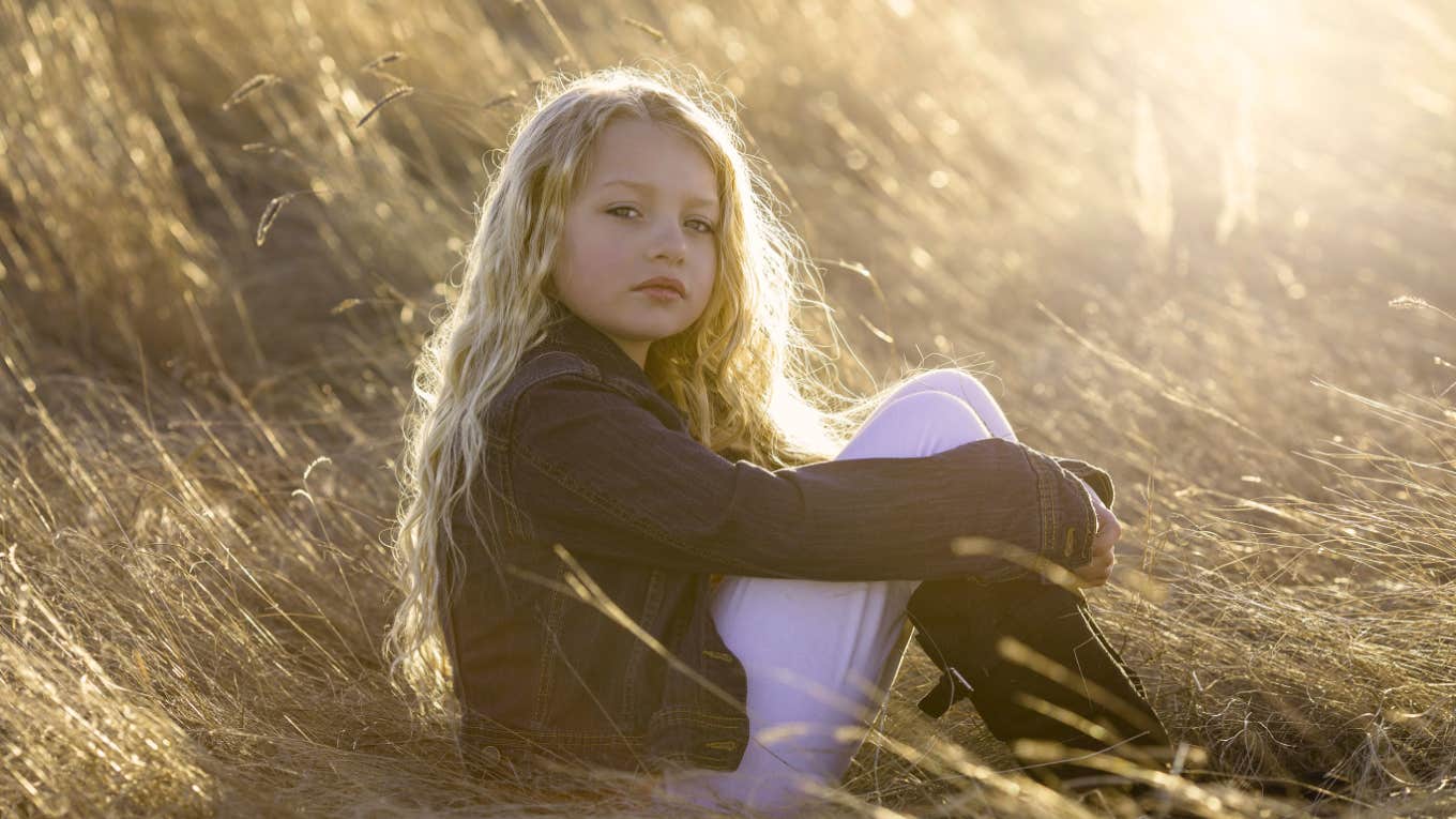 Diagnosed Psychopath Reveals What She Was Like As A Kid serious young blonde girl sitting outside in field